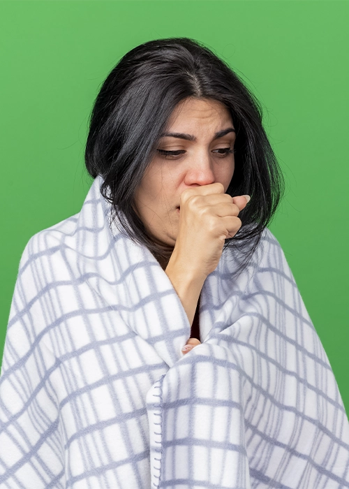 Persona con tos cubierta con manta